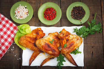 Plate of chicken wings on wooden table, top view.