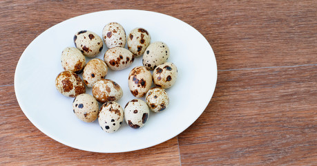 top view of raw quail eggs on a white plate