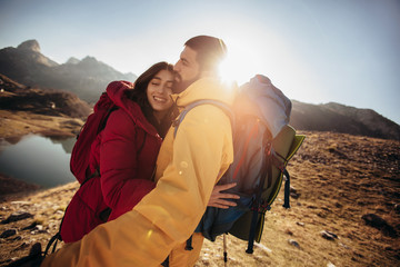 Fototapeta premium Couple of hikers walking on a mountain at autumn day near the lake.