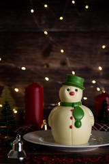 Christmas and winter holidays table night with Snowman chocolate Set on wooden table with Christmas decorations.