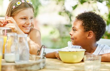 Mädchen und afrikanischer Junge beim Frühstück