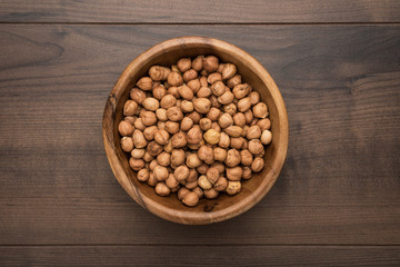 photo of a bowl full of hazelnuts on the brown wooden table