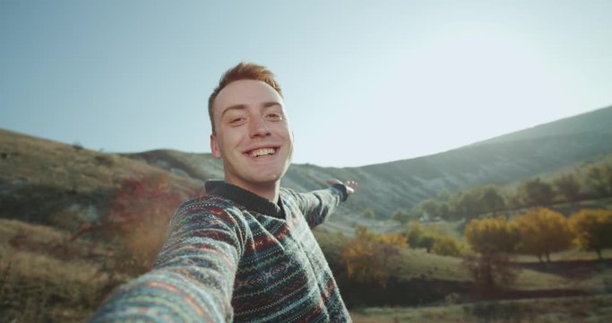 Redheaded boy in a trip time filming his self and taking some video for memories in top of mountains. shot on red epic