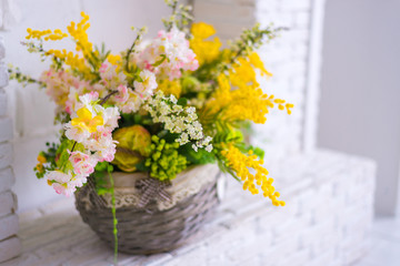 Floral spring decor in a basket. Decorative fireplace