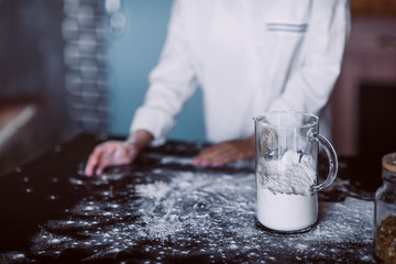 Women's hands preparing flour. Cook in the kitchen prepares bakes pies from flour. Pizza Makes Pizza Dough. Making pasta
