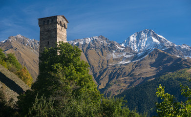 Fototapeta na wymiar Old stone tower among high mountains