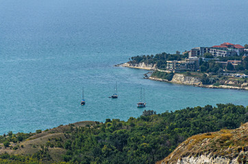 Green Thracian cliffs near blue clear water of Black Sea, golf boats, rocky path seaview
