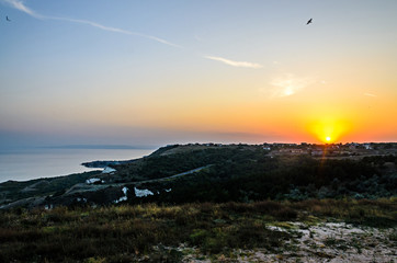 Green Thracian cliffs near blue clear water of Black Sea, sunset path seaview