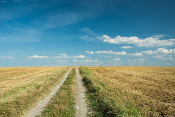 Obraz premium Country road in the direction of the clouds