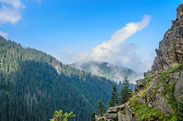 The Transfagarasan road in Fagaras mountains, Carpathians with green grass and rocks, peaks in the clouds