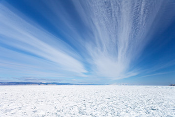 Lake Baikal in winter. Beautiful stratus clouds above the field of snowbound ice hummocks on Small Sea (Maloe More) Strait. Natural  background - obrazy, fototapety, plakaty