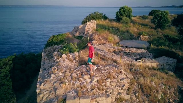 Man on castle ruins aerial shot, Sithonia, Greece