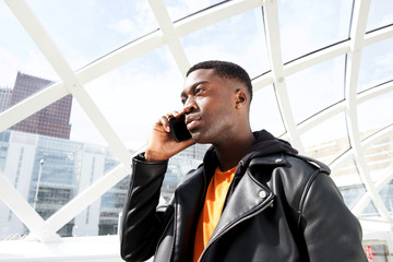 Close up cool young african american man talking on mobile phone in city