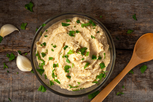 Homemade spread made from mashed boiled beans, oil and garlic in bowl