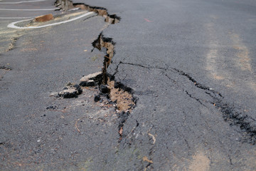 crack on asphault rural road. damaged collapsed street