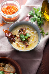Lentil soup puree with bacon in a bowl on a dark wooden background. Close up shot