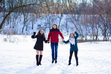Fototapeta na wymiar group of friends jumping together in the park in winter