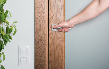Naklejka premium Close - up of interior elements. Open the door. Man's hand on the door handle