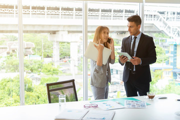 Business people working in office. Using mobile and tablet for online conference with partner.