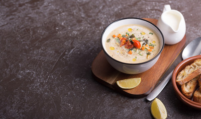 Lentil soup puree with bacon in a bowl on a dark wooden background