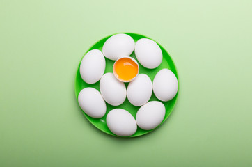White eggs and egg yolk on the green background