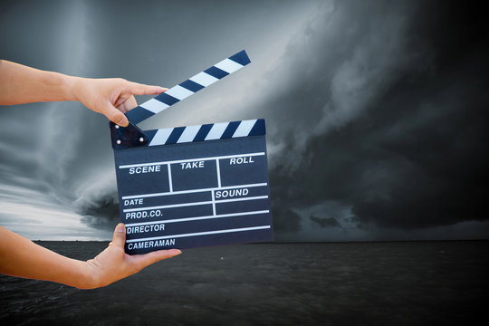 Man hands holding movie clapper.Film director concept.camera show viewfinder image catch motion in interview or broadcast wedding ceremony, catch feeling, hand hold a Film Slate with storm cloud.
