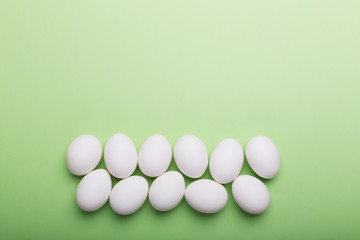 White eggs and on the green background with copy space