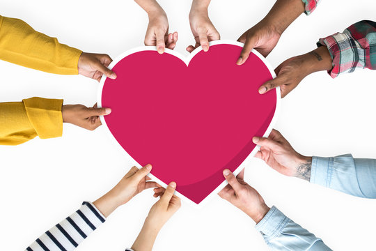 Diverse hands holding a red heart