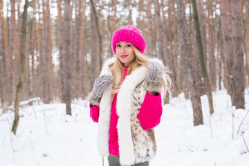 Fototapeta na wymiar Fashion and people concept - Lovely young woman in warm jacket in winter park