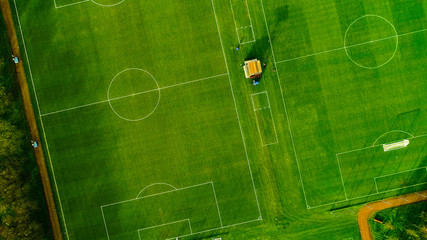 Aerial image over artificial grass football pitches. Long shadows thrown by a low sun.