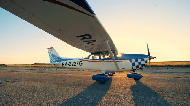 One airplane moving on a sunset background, side view.