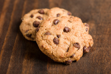 Detail of gluten-free craft biscuits whit chocolate nuggets over rustic wooden background