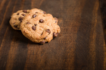 Detail of gluten-free craft biscuits whit chocolate nuggets over rustic wooden background