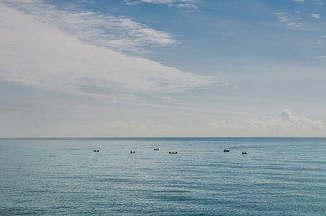 Obraz premium fishing boats far into the sea under the sky
