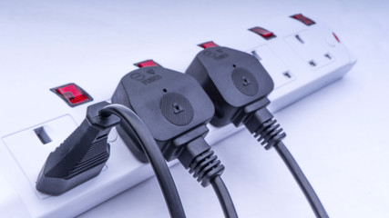 Extension cord and power plug on white background with selective focus and crop fragment