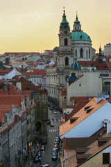 Obraz premium Prague, Czech Republic, September 19, 2018. Beautiful evening view from above on the city, the red roofs of houses in Mala Strana and the church of St. Nicholas
