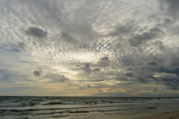 Landscape of a beach at sunset with clouds and ocean in the horizon