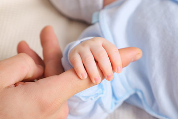 Soft focus of baby hands and mom. New family and baby protection concept