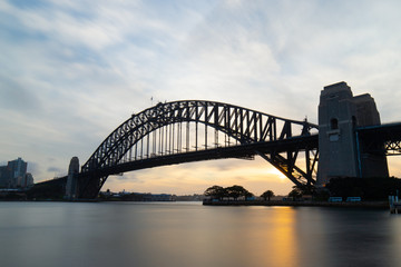 Long exposure view of Sydney Harbour Bridge at sunset time.