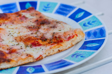 Pizza with ham, mozzarella, tomato sauce on the plate