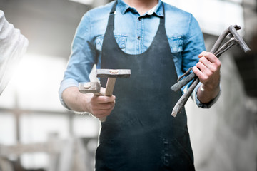 Sculptor with working tools in the studio. Close-up view with no face