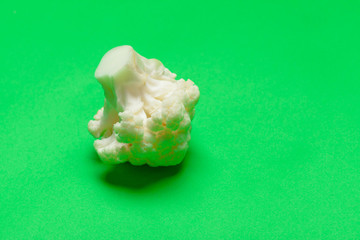 Cauliflower pieces on a bright green background