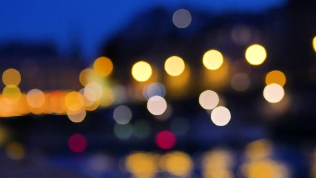 Voluntary blur of Paris, in the night. There are decorations that allow you to create a background by changing the focus. The lights are moving, it's a boat passing through the water.
