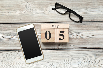 wooden cube shape calendar for MAY 5 on wooden background