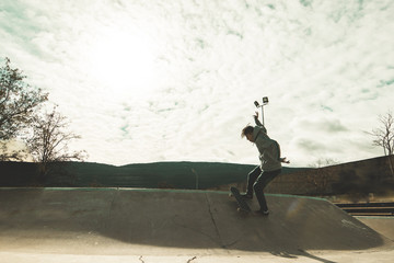 Obraz na płótnie Canvas Guy doing skateboarding tricks at the skatepark