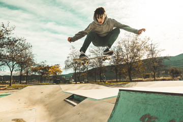 Guy practicing skateboarding and doing tricks in a skatepark © Rafa