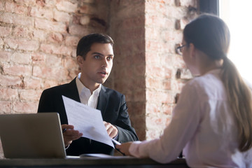 Outrage boss talking to employee, pointing at error in document. Young woman gets scolded by chef....