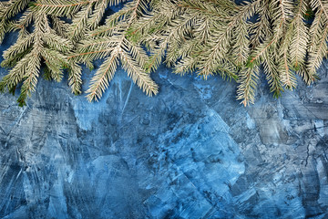 Spruce branches covered with hoarfrost. Christmas composition with copy space. Festive layout with place for text on a dark blue background .