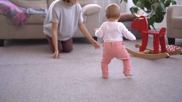 Mother with baby girl learning to walk