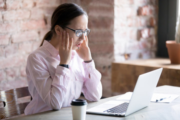 Shocked businesswoman looking at laptop screen. Unpleasantly surprised employee after receiving bad news. Frustrated young woman.